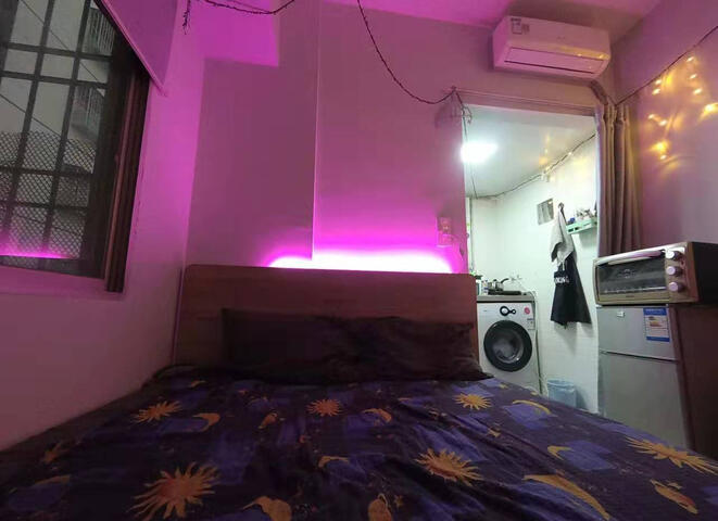 photo of the bed next to the fridge and electric oven